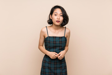 Asian young woman over isolated yellow wall with surprise facial expression