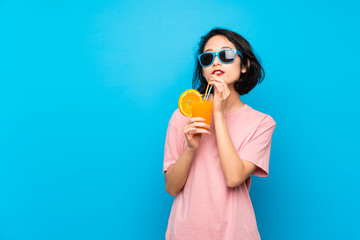 Asian young woman over isolated blue background holding a cocktail
