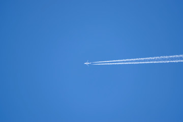 Condensation trail from an airplane in a blue sky. flying a passenger plane.