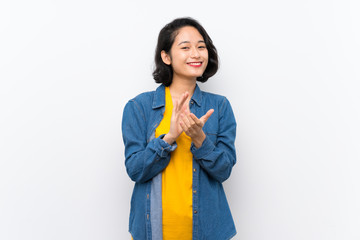 Asian young woman over isolated white background applauding after presentation in a conference