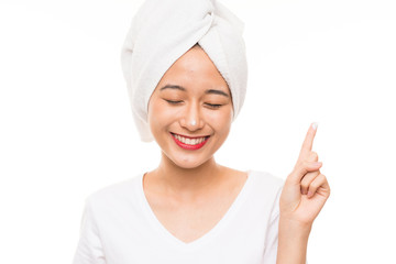 Asian young woman over isolated background with moisturizer