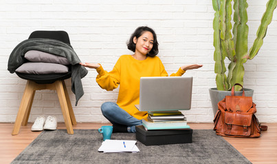 Asian young woman sitting on the floor having doubts with confuse face expression