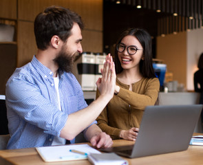 Business colleagues are motivated, giving high five and celebration successful deal. Cooperation...