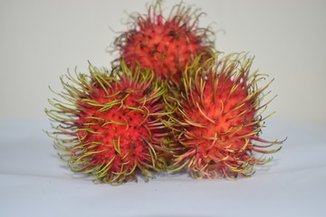 Fototapeta premium Fresh red rambutans fruit on white colour background 