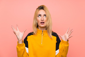 Young blonde woman over isolated pink background frustrated by a bad situation
