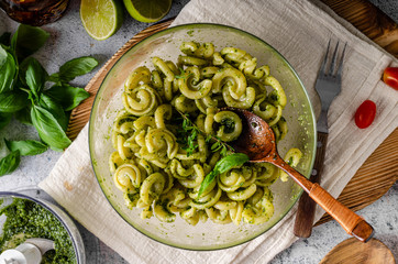 Homemade pasta with fresh basil pesto and tomatoes