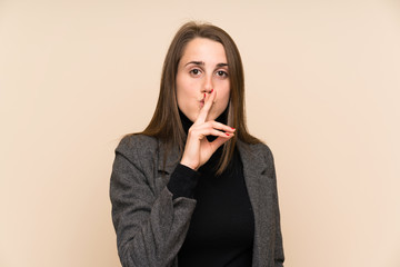 Young woman over isolated wall doing silence gesture