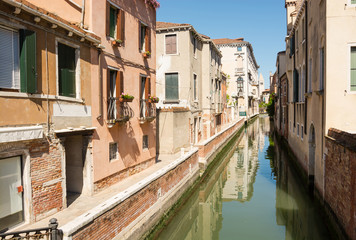 Fototapeta na wymiar View of the city narrow street, bridge and canal in Venice, Italy