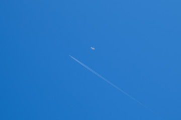 Two passenger aircraft flying nearby. Condensation trail from an airplane in a blue sky.