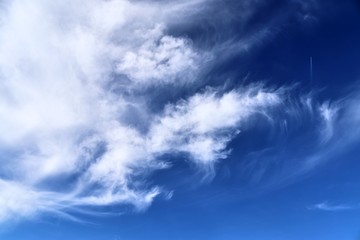 Beautiful white cirrus cloud formations on a deep blue summer sky