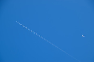 Two passenger aircraft flying nearby. Condensation trail from an airplane in a blue sky.