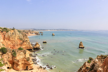 Fototapeta na wymiar Panoramic landscape view of golden cliffs and emerald water in Camilo beach (Praia do Camilo) in Lagos, Algarve, Portugal