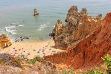 Scenic landscape view of golden cliffs and emerald water in Camilo beach (Praia do Camilo) in Lagos, Algarve, Portugal
