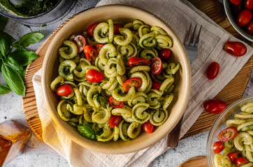 Homemade pasta with fresh basil pesto and tomatoes