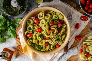 Homemade pasta with fresh basil pesto and tomatoes