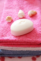 Obraz na płótnie Canvas white toilet soap and decor against the background of pink terry towels