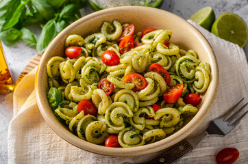 Homemade pasta with fresh basil pesto and tomatoes