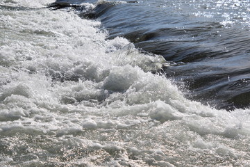 Stromschnellen im Fluss, glänzend im Sonnenlicht