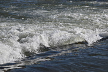 Stromschnellen im Fluss, glänzend im Sonnenlicht