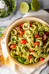 Homemade pasta with fresh basil pesto and tomatoes