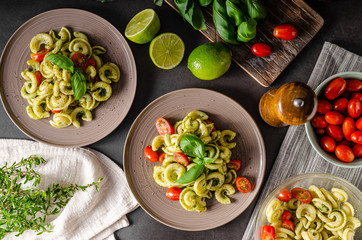 Homemade pasta with fresh basil pesto and tomatoes