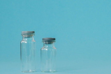 Vial of medicine on blue background with copy space. Antibiotic or vaccine medication. Healthcare and pharmacy innovations