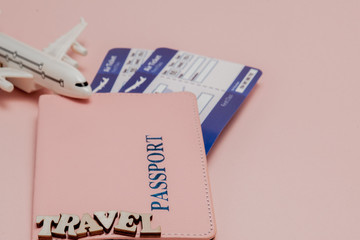 Inscription travel , Airplane, air ticket and money on a pink background. Travel concept, copy space