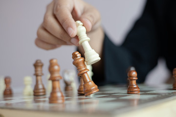 Close up shot hand of business woman playing the chess board to win by killing the king of opponent...