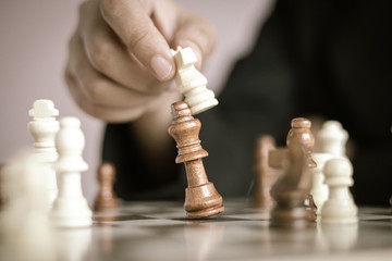 Close up shot hand of business woman playing the chess board to win by killing the king of opponent metaphor business competition winner and loser select focus shallow depth of field