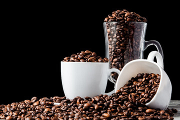 Black coffee in white cup and coffee beans on black background. Top view, space for text