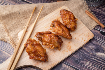 Hot and spicy Korean barbeque fried chicken on wood cutting board