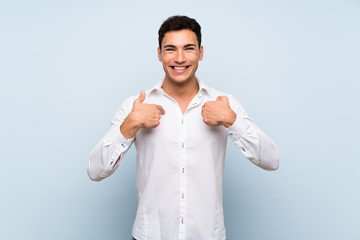 Handsome man over blue wall with surprise facial expression