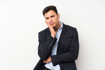 Handsome man over isolated white wall unhappy and frustrated