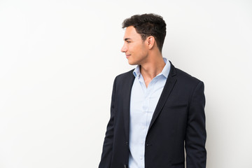 Handsome man over isolated white wall looking to the side