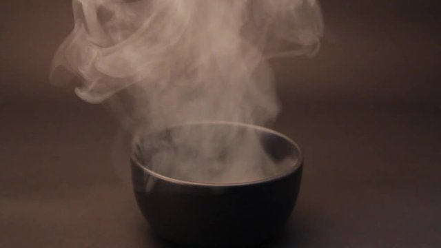 Smoke from the bowl of noodles on a black background.