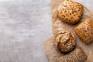 Assortment of baked bread on wooden table background.
