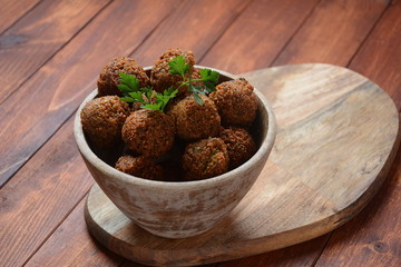 Falafel balls with parsley in wooden bowl with tahini sauce. Vegan healthy food 