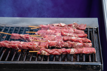 Open barbecue grill with beef kabob grilling and smoke from fire