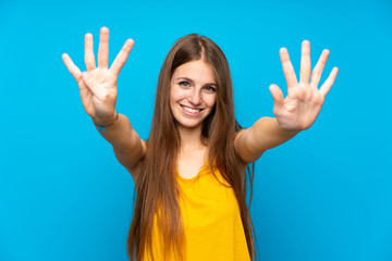 Young woman with long hair over isolated blue wall counting nine with fingers