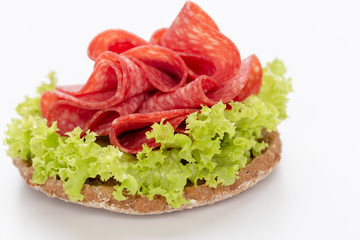 Sandwich with salami sausage on white background.
