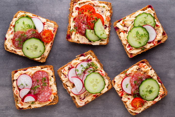Sandwiches with cream cheese, vegetables and salami.