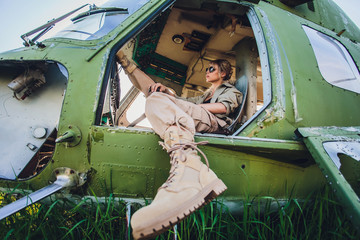 Female pilot in cockpit of helicopter before take off. Young woman helicopter pilot. © Евгений Вершинин