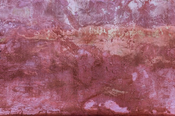 An old dyed colorful wall is covered with cracks and scratches.