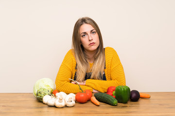 Fototapeta premium Woman with lots of vegetables sad