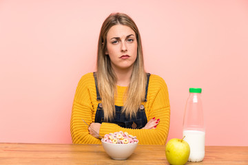 Young woman with bowl of cereals sad