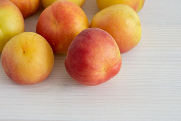 Top view of apricots on white wooden background