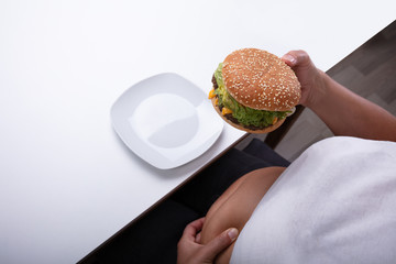 Overweight Woman Holding Hamburger In Hand