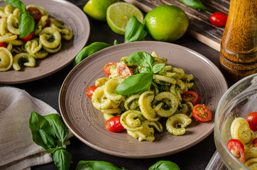 Homemade pasta with fresh basil pesto and tomatoes