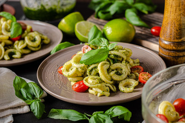 Homemade pasta with fresh basil pesto and tomatoes