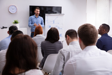 Naklejka na ściany i meble Businessman Giving Presentation To His Colleagues